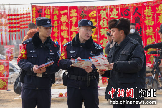 图为民警在辖区大集进行反诈宣传。